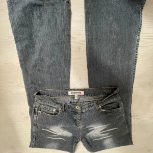 Lågmidjade bootcut jeans - Snygga jeans med slitna detaljer framtill. Byxorna har en bootcut-stil och är lågmidjade. Midjemåttet 39, Innerbenslängd 84 och grenmått 19. Jag är 167💗