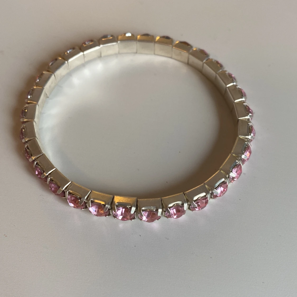 Silverfärgat armband med rosa stenar