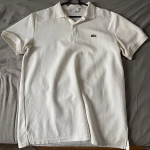 Lacoste piké - Säljer en vit pikétröja från Lacoste, Storlek M och i fint skick utan skador, fläckar eller liknande.