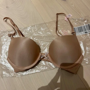 Beige bh med bygel - Säljer en beige bh från Victoria's Secret i storlek. 32B, vilket motsvarar 75A. Den är helt ny. Den har bygel och justerbara axelband för bästa passform. Materialet är mjukt och bekvämt, perfekt för dagligt bruk.