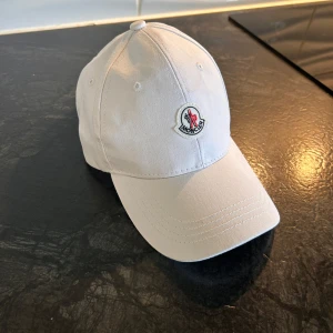 Helt ny vit moncler keps  - Säljer min vita moncler keps som har aldrig används helt ny och ren priset kan diskuteras 