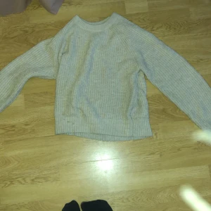 Beige stickad tröja från Lindex Kids - Säljer en supermysig beige stickad tröja från Lindex Kids. Perfekt för kyliga dagar med sin mjuka och varma känsla. Tröjan har långa ärmar och en klassisk rund halsringning. Passar perfekt för både höst och vinter!