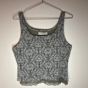 Mönstrad magtröja topp i mesh vintage - Coolt kort topp med mönster fram och bak till gjort i meshtyg, med henomskinlig tyll detalj nertill.   Slutar till under bröskorgern så är magtröja. Passar s-m beroende på hur tajt den ska sitta.
