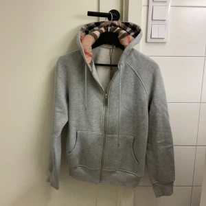 Burberry hoodie  - Säljer nu denna burberry hoodie, ej äkta. Vågar inte lägga ut den som äkta då jag inte vet. Den är i barn storlek L Motsvar xs, xxs. Hör av er angående frågor eller vid funderingar. Pris kan diskuteras.