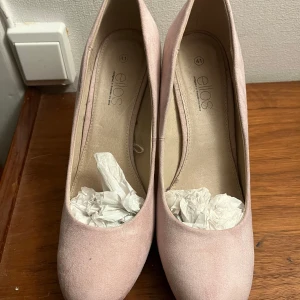 Rosa pumps från Ellos - Säljer ett par eleganta rosa pumps från Ellos i storlek 41. Hög klack och spetsig tå, perfekta för festliga tillfällen. Skorna är i använt men bra skick och har en stilren design som passar till både klänning och byxor☺️
