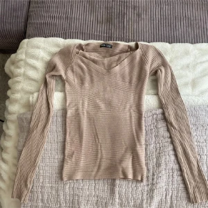 Beige ribbad tröja - Säljer en snygg beige ribbad tröja från shein. Den har en v-ringad hals och långa ärmar, perfekt för höst och vår. Tröjan är i bra skick och passar både till vardags och lite finare tillfällen. Superbekväm och stilren!
