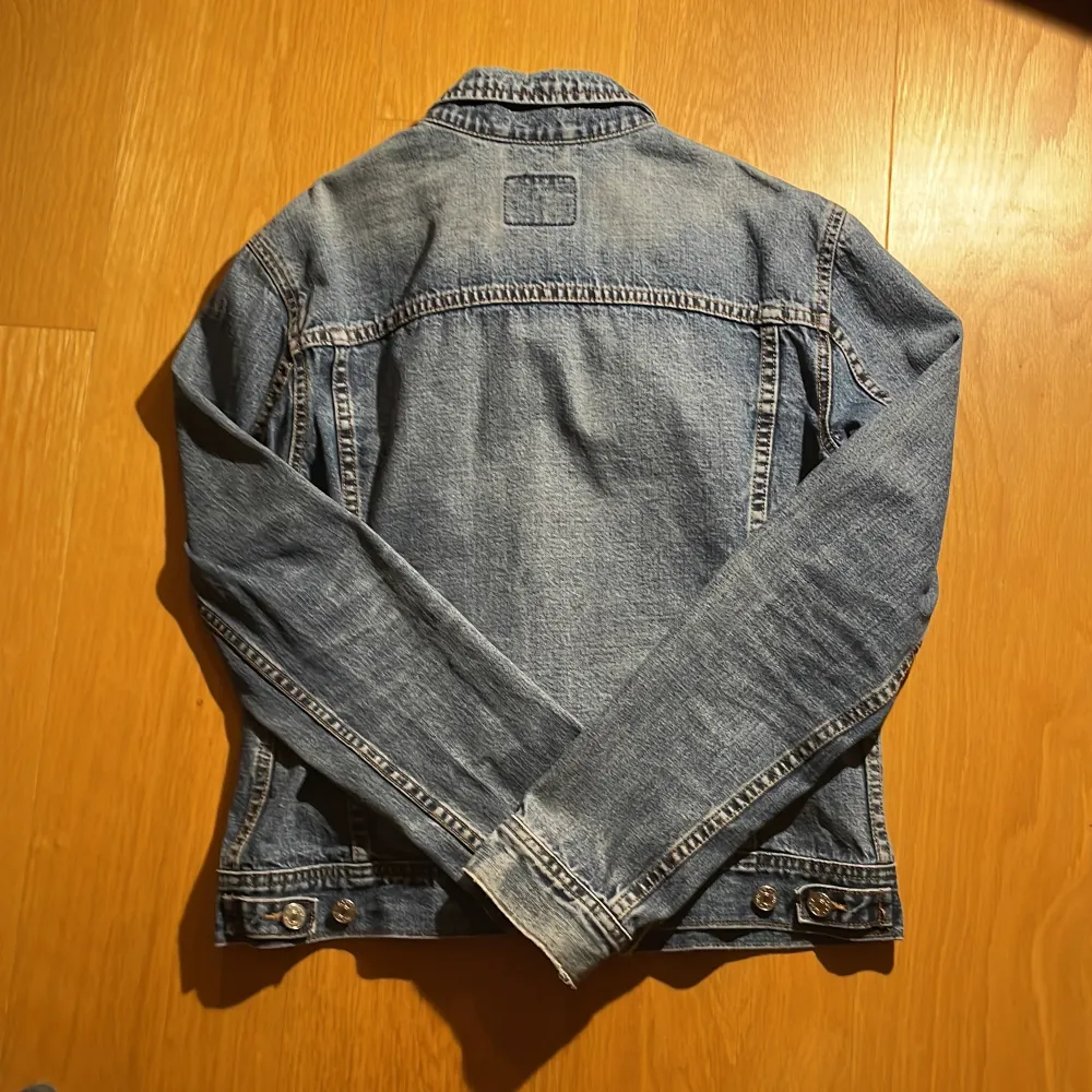 Säljer en klassisk blå jeansjacka från Rocky i storlek M. Jackan har en tidlös design med knappar framtill och två bröstfickor med lock. Perfekt för vår och sommar, och funkar till nästan alla outfits. Den är i bra skick och redo för nya äventyr! 💙. Takit.