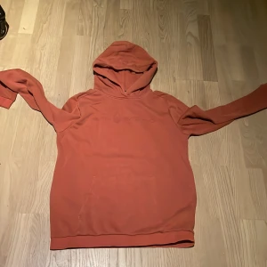 Rostfärgad hoodie från Sail Racing - Säljer en snygg rostfärgad hoodie från Sail Racing. Perfekt för kyliga dagar med sin mjuka och bekväma passform. Den har en klassisk design med huva och långa ärmar. Passar både till vardags och för avslappnade tillfällen. Hör av dig vid intresse!