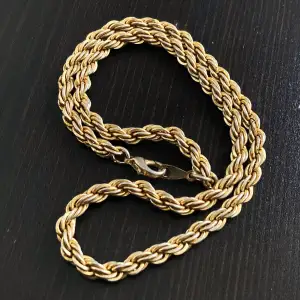 Kort guldfärgat halsband, slitage finns. Längd: 41,5 cm, bredd: 5 mm.