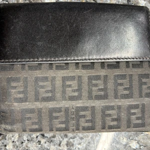 Äkta Fendi plånbok i skinn och tyg - Säljer min Fendi-plånbok i fint använt skick, men har fortfarande mycket kvar att ge. 