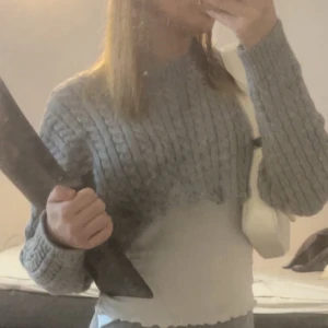 Stickad tröja  - Kort grå stickad tröja man kan ha tröja under använd en gång 