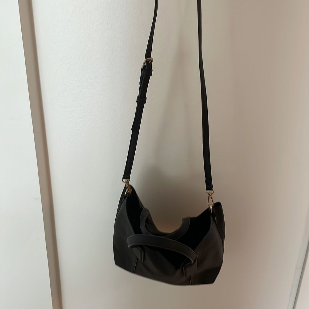 Mango black bag. With long strap that is removable. One pocket inside the bag. Black leather with gold details.. Väskor.