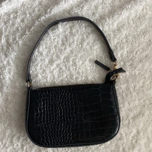 Väska  - En liten svart väska i fake läder. 