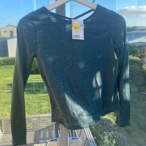 Lindex tröja barn - Super söt Grön tröja med giltter och ett fint kors i ryggen, helt oanvänd med lapp kvar!😃 köparen står för frakt! I storlek 134/140 från Lindex<3