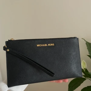 Michael Kors-clutch - Clutch från Michael Kors som jag använt 3 gånger. Det går ej att sätta på eget band för att göra den till en liten väska, utan den är gjord för att hålla i. Köparen står för frakten🌼