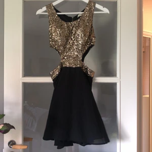 Guldig paljettklänning - Guldig paljettklänning med utskurna partier vid midjan. Använd 1 nyår för flera år sedan. Dragkedja i bak. 