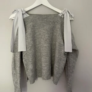 Sweatshirt med snörning  - Grå sweatshirt med öppning vid axlarna där man knyter över. Strl 34