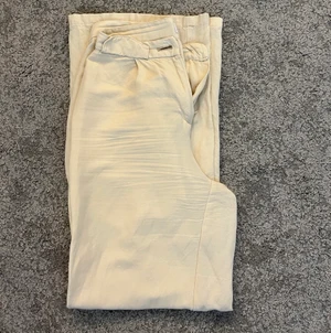 Linnebyxor  - Linnebyxor från Bershka i storlek 34. Väldigt bra sick, då de använts fåtal gånger. Färgen på byxorna är beige/vita. Köparen betalar för frakten.