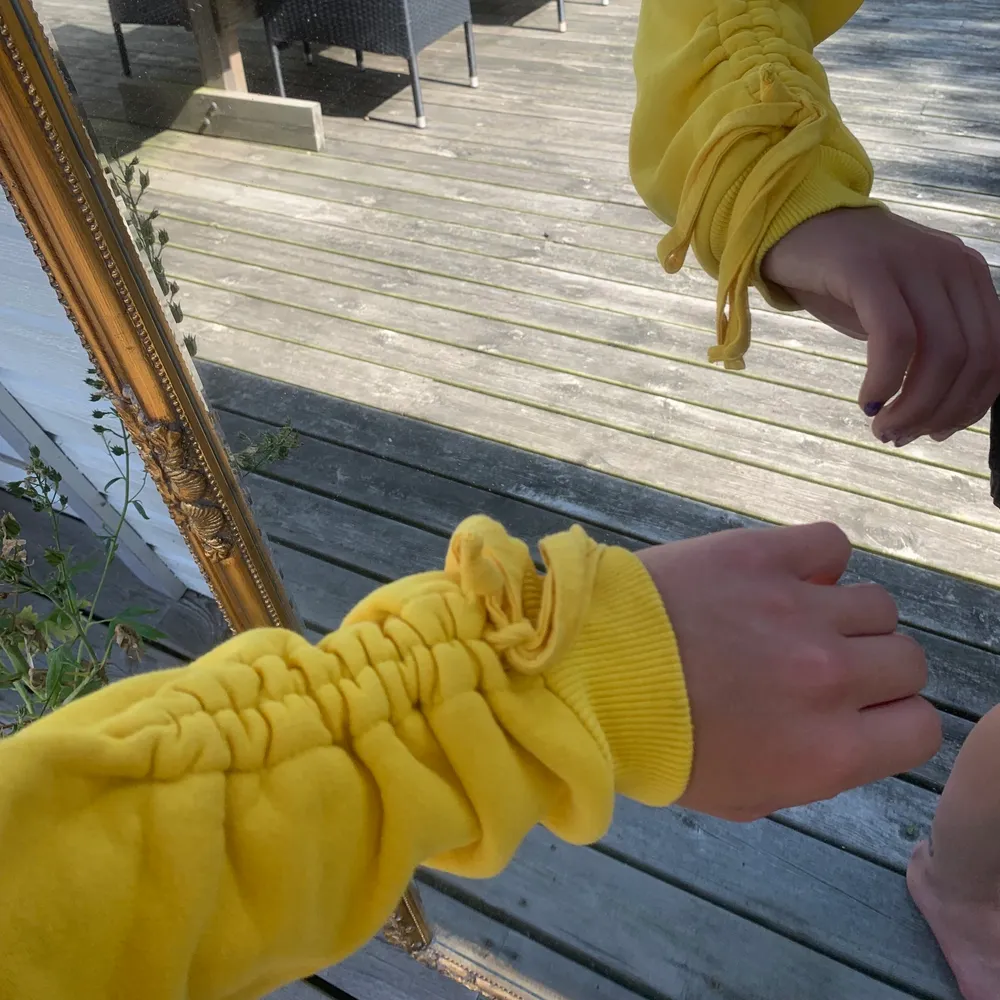 Söt gul croppad hoodie köpt från Urban Outfitters med cool snörning på armarna ✨. Hoodies.