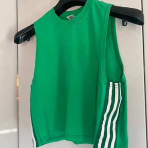 Grönt linne - Grönt linne med ”adidas” streck, storlek xs men passar nog även s/m