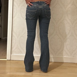 Skit snygga Botcut Lågmidjade jeans  - Sååå Cooolllaa och unika Lågmidjade blåa jeans. Midjemått:74cm ( stretchiga! Passar mig som har 80+ som midjemått)  Ytterben: 99cm  Innerben:79