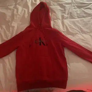 Röd fin hoodie. Med märket calvin Klein äkta. Storlek S. Använd två gånger då jag inte tyckte om den. Nästan nyskick. Köpt på Sweoutlet. Köpte hoodien för 1200kr. 