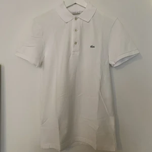 Lacoste Vitt Piké Tröja  - Lacoste Vitt Piké Tröja   Storlek herr XS slim fit  Använd fåtal gånger så i toppen skick 
