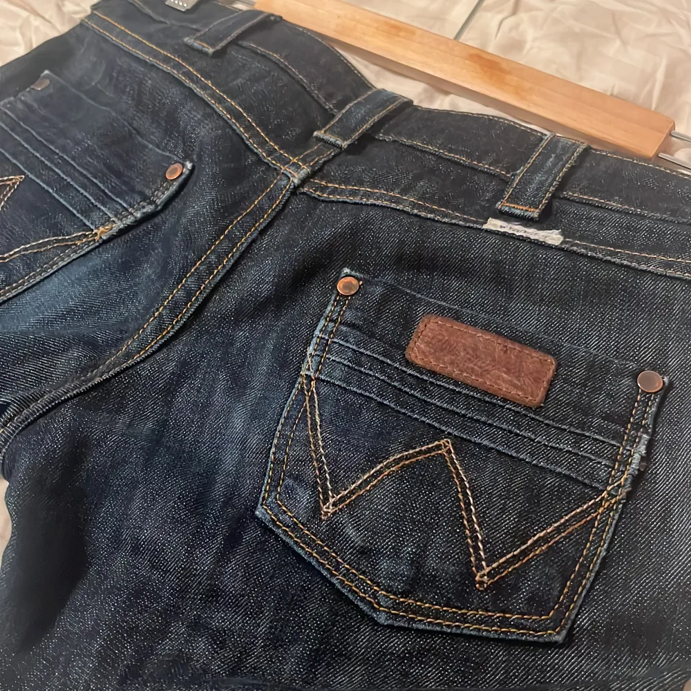Mörkblå lågmidjade jeans från Wrangler. Modellen är straight/bootcut. Bra skick, inga defekter. Säljer då de tyvärr blivit för små för mig.😊. Jeans & Byxor.