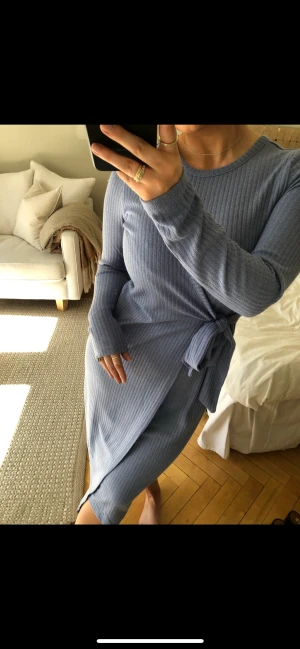 Blå klänning - En blå stickad klänning med knytning i sidan.   Storlek 36/38.  Använd en gång.