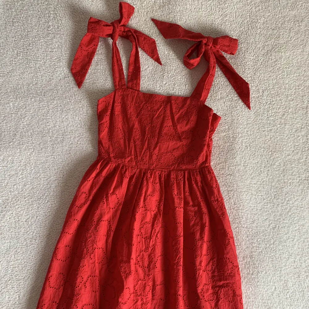 Såå himla fin röd blommig klänning med rosetter vid axlarna från H&M. Den har aldrig blivit använd och förtjänar att komma ut i vår och sommar. Dyr i inköp. Inga anmärkningar förutom lite skrynklig.. Klänningar.