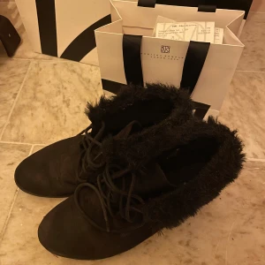 Fina vinterskor svarta kilklack - Sköna och fina vinterskor i tyg med lite kilklack. Gummisula. Bara använt några få tillfällen!