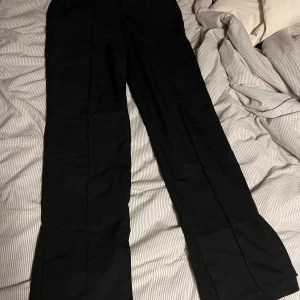 Utsvängda kostymbyxor NA-KD - Säljer dessa snygga utsvänga kostymbyxorna med slits från NA-KD i strl 40