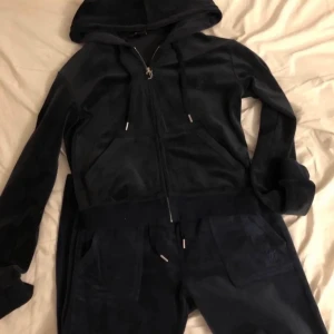 Juciy coture sätt  - Säljer mitt favo mörkblått juciy coture sätt. Jag tar bara emot Swish och köparen swishar mig först och postar dagen efter.⭐️Storlek S i byxorna och M i tröjan ( sitter lite oversized på mig som har xs/s). Lite missfärgat men syns inte. 1450kr för allt