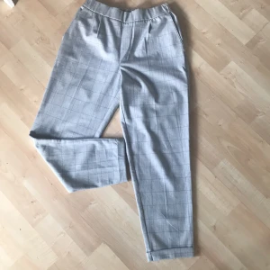 Byxor pull and bear - Grårutiga byxor storlek S.  längd 85cm och som nya. 