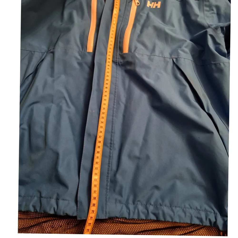 HellyHansen, xl. Sparsamt använd och är i bra skick.  71cm längst framsidan (bild 2) Precis under ärmarna är den ca 62cm bred och längst med nedre kant är den ca 61cm (bild3). Jackor.