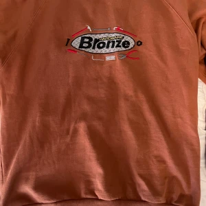 Bronze - Snygg sweatshirt från Bronze hardware köpt på Hollywood i Stockholm för 1400. Älskar färgen på den och det broderade trycket. Sitter true to size. Den e i bra skick använd max 10 gånger. Möts gärna upp i Stockholm:)
