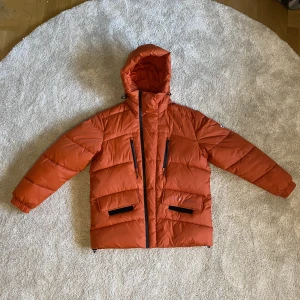 Ny Tommy Hilfiger vinter jacka - Riktigt varm ny orange röd, Tommy Hilfiger VinterJacka i storlek S. Har bara använts en gång och i otroligt skick. Kan hämtas i Uppsala men kan också frakta