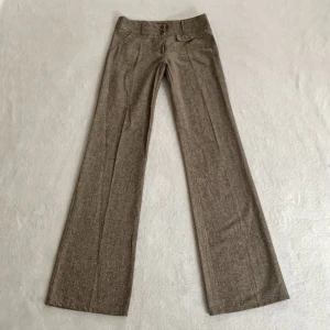 Bruna kostymbyxor - Lågmidjade utsvängda bruna kostymbyxor med glitter i sig, från okänt märke! Jag är 173 cm (för små på mig), midjemåttet är 70 cm och innerbenslängden 86 cm 🤍