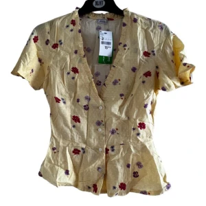 Blommig blues  - Oanvänd gul blommig blues från Pimkie, blusen jättesöt och mjuk.,storlek 34