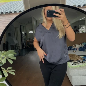 V-ringad topp - Säljer en supersöt v-ringad topp/väst med glansigt sidenmaterial i en assnygg blå/grå färg! Kan ha som offshoulder eller vanligt 🧸