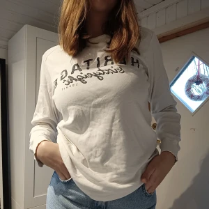 Vit sweatshirt med tryck - Jag säljer en vit sweatshirt med tryck! Knappt använd, bra skick! Storlek L men passar på mig som är mer M. Frakt tillkommer till priset<3