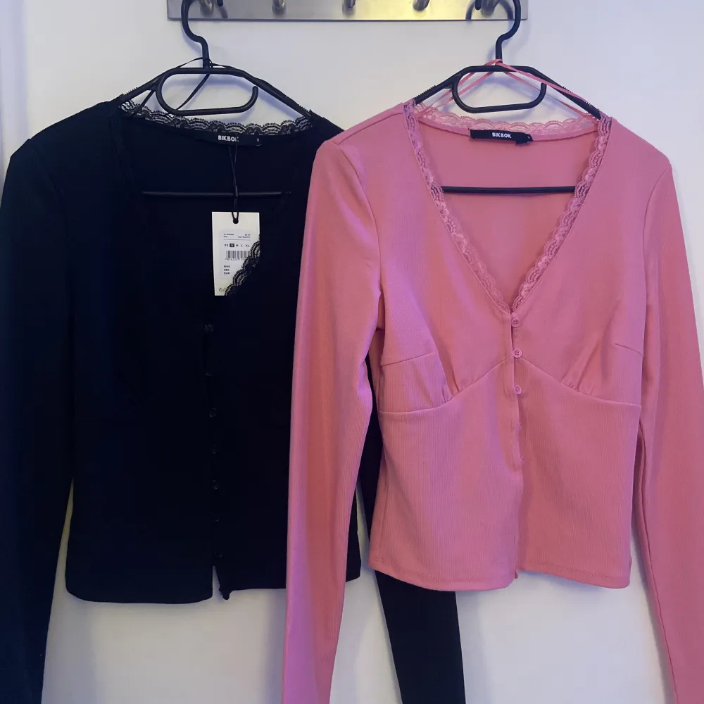 Två långärmade tröjor från bikbok i storlek S, knappar i mitten med spets på u ringningen, båda är som nya, rosa tröjan har bara tappad prislappen, kan sälja båda för 200kr men annars 120kr st💕. Toppar.