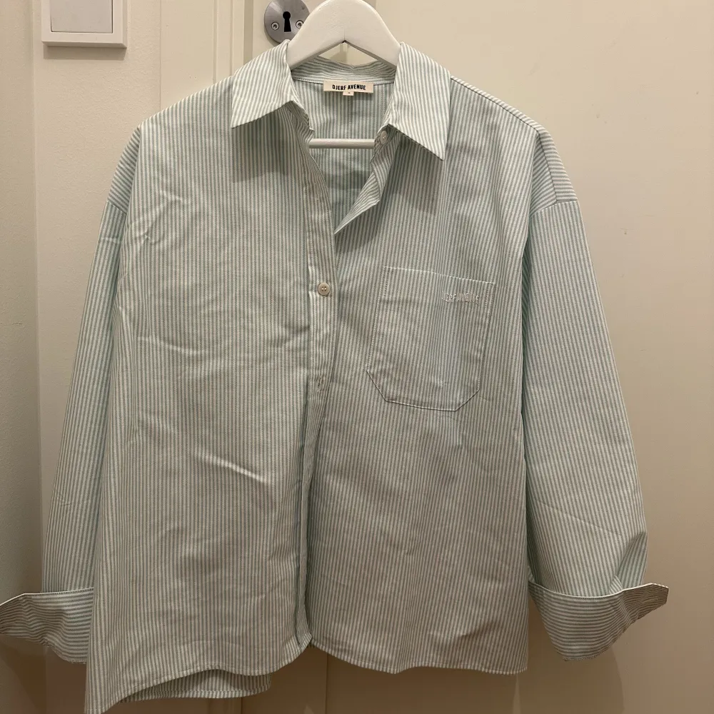 Breezy shirt green stripe. Använd 1 gång, skicket är nytt och skjortan känns som ny. Dock finns det en svag sminkfläck på insida av krage. Inget som syns vid användning. Har inte försökt tvätta. Vid intresse av köp kan jag lämna in skjortan på dry clean. . Skjortor.