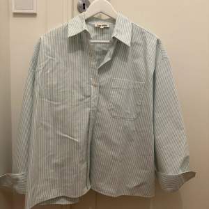 Breezy shirt green stripe. Använd 1 gång, skicket är nytt och skjortan känns som ny. Dock finns det en svag sminkfläck på insida av krage. Inget som syns vid användning. Har inte försökt tvätta. Vid intresse av köp kan jag lämna in skjortan på dry clean. 