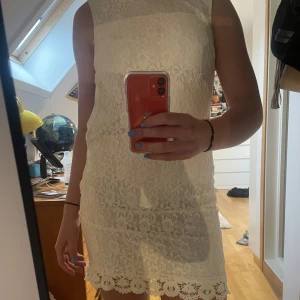 Klänning - Supersöt vit spetsklänning som på mig, 169cm, går ovanför knäna. Dragkedja i sidan som på mig inte går att knäppa men den fungerar😽Låg i ryggen. Fin, ganska hög ringning. Köpt från Zalando för 900kr. Mycket bra skick, använd två gånger!
