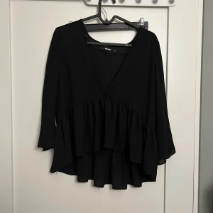 Blus från Bikbok i strl. XS - Svart blus från Bikbok i strl xs i skirt material, superfin till en svart spets-bh under.