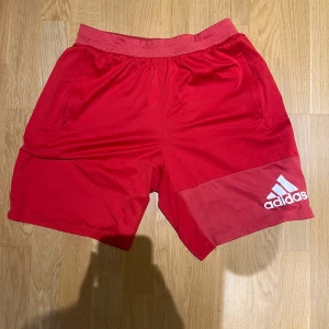 Adidas Sportshorts - Adidas Sportshots som är bra att träna i och snygga. Färgen är röd och storleken är M. Nypris: 300