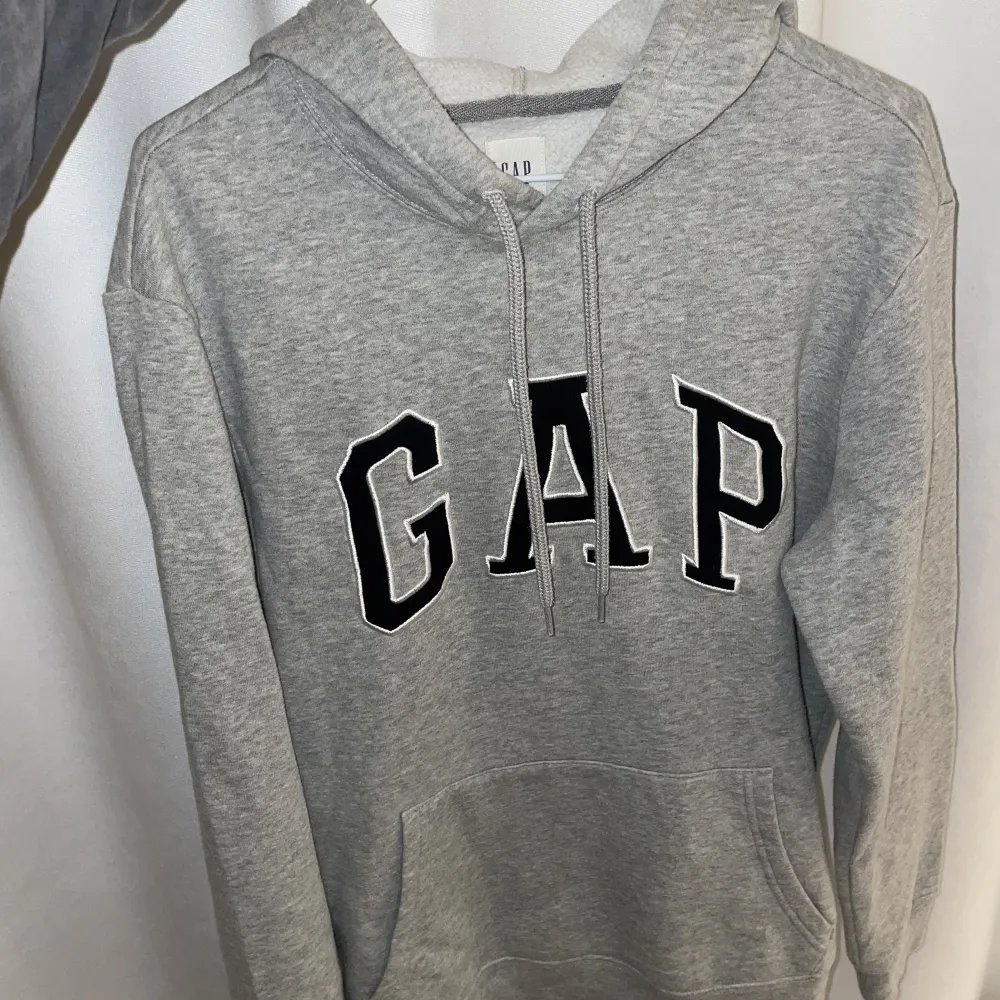 Grå Gap Hoodie, storlek xs. Den är använda men i hyfsat bra skick. Hoodies.