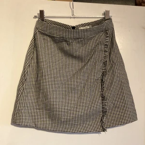 Hundtandsmönstrad kjol - Kort kjol med hundtandsmönster och detalj. Liten i storlek! 