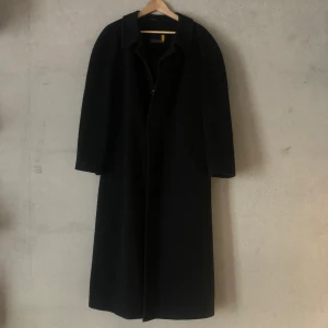 Kappa kashmir oversize - Fin och varm kappa i kashmir och ull-mix. Passform oversize, utan att vara för lång i ärmarna. Mkt bra skick, förutom liten reva i innerfodert vid slitsen bak. Plaggets längd: 128 cm